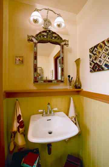 Oil paintings by Esta Kornfield harmonize with the wainscoting in the master bathroom.